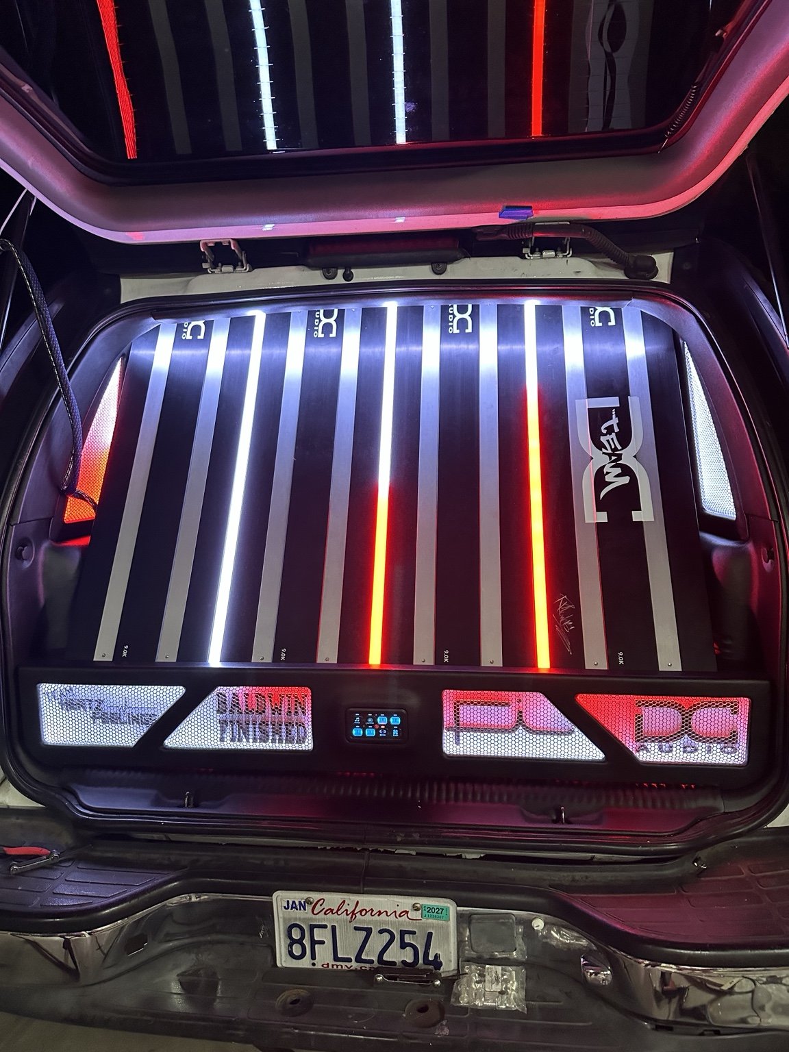 Illuminated custom amplifier display in the rear of a vehicle