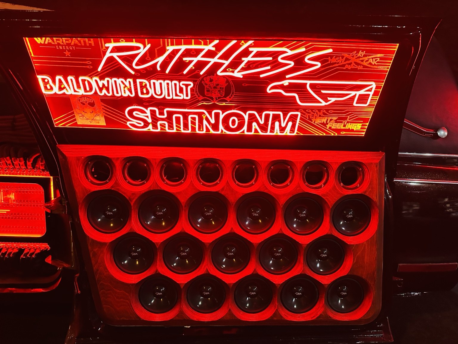 Illuminated subwoofer wall with red lighting and branded trim